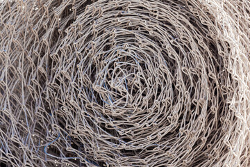 Steel mesh netting, twisted into a roll, close-up.