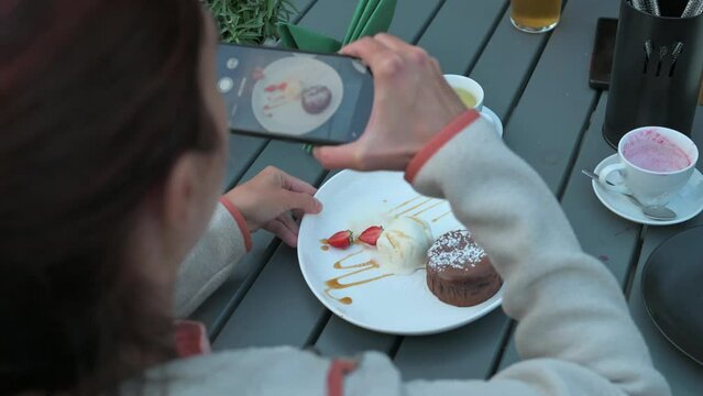 Woman taking fotos on breakfast. Shooting desser. 4k video footage