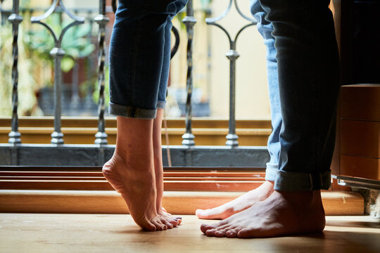 Top view of young intimate couple relaxing next to a window with a balcony at home.