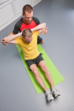 personal trainer helping client in gym