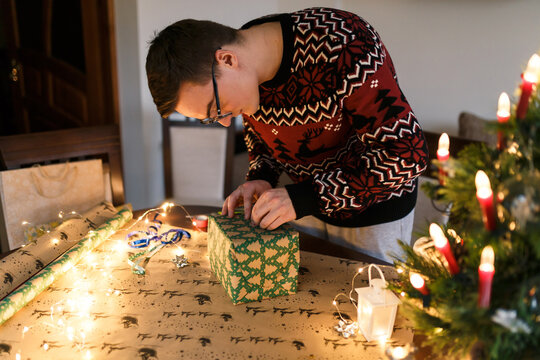 young man packs Christmas presents for friends and family