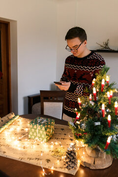 man taking pictures on smartphone carefully wrapped Christmas present