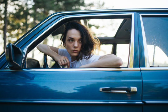 Woman sitting in a parked vintage car