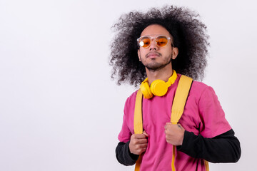 Portrait with pink t-shirt and backpack for the university. Young man with afro hair on white background