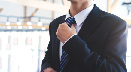 Businessman  adjusting his neck tie.