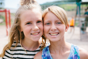 Tween friends with faces together happy and smiling outside