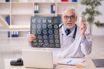 Old male doctor radiologist working in the clinic