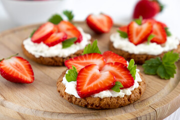 Homemade healthy crispbread bruschetta with strawberry and cream cheese. Healthy snack, keto diet or dieting concept. Recipe of vegan food for everyday cooking.