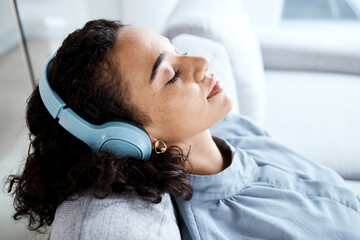 Face, woman and headphones for listening to music for calm, peace and mindfulness on home couch....