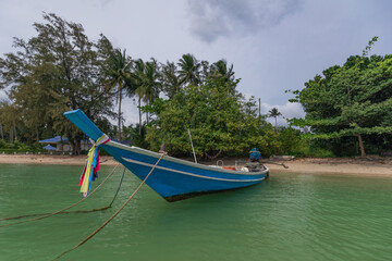 Traditional Thai longtail boat with colorful ribbons decorated nose on sandy beach Samui Thailand