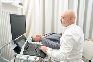 Professional ultrasound specialist is examining health of patient in hospital