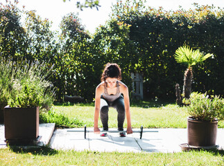 young woman exercising in her home garden