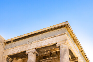 Sun hiding behind the columns of the Parthenon temple at Acropolis site on a sunny evening in Athens Greece