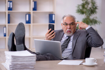 Old male employee working in the office