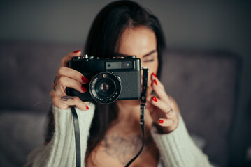 Hipster girl using an old-fashion camera closeup