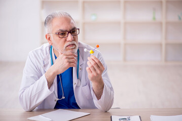 Old male doctor working in the clinic