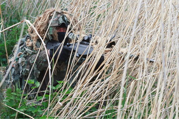 sniper sneaking through the dry grass