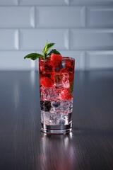 Ice-cold carbonated drink with raspberries, blackberries and blueberries. Selective focus.