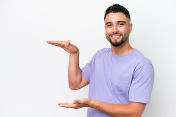 Young Arab handsome man isolated on white background holding copyspace to insert an ad