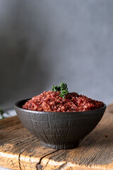 Homemade red wine infused salt in a black bowl. Condiment to aromatize and season food