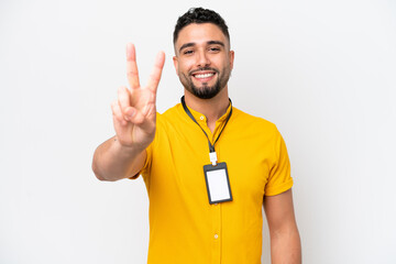 Young Arab man with ID card isolated on white background smiling and showing victory sign