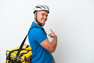 Young caucasian man with thermal backpack isolated on white background pointing back