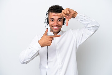 Telemarketer Brazilian man working with a headset isolated on white background focusing face. Framing symbol