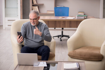 Old male employee working from home during pandemic