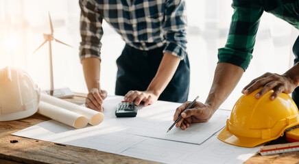 Close up of business people having consultation about wind energy at company office. Asian industry professional team in sun light