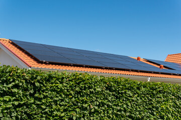 Solar battery panel on a roof of a private house in Europe. Energy-saving technology. Sunny summer day. - obrazy, fototapety, plakaty