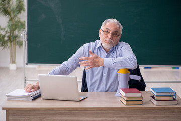 Old male teacher in the classroom