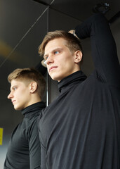 Obraz premium a handsome man in a black sweater looks at the camera