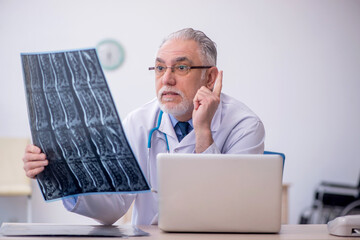 Old male doctor radiologist working in the clinic