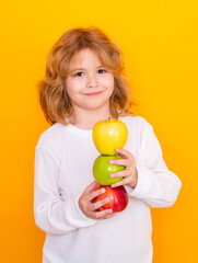 Vitamin and healthy fruits for kids. Kid with apple in studio. Studio portrait of cute child hold apple isolated on yellow background.