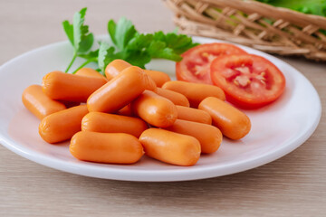 Mini sausage and vegetable on white plate.