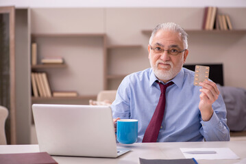 Obraz premium Old male employee feeling bad at home