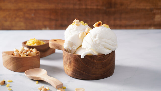 Coconut ice cream topped with roasted peanuts in a coconut shell macro shot. (spot focus)