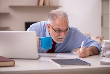 Old male employee working from home during pandemic