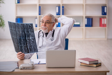 Obraz premium Old male doctor radiologist working in the clinic