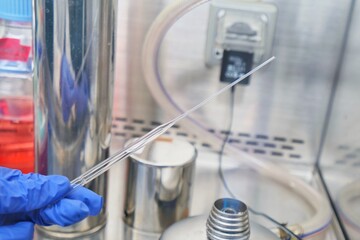 The researcher using bunsen burner to sterile technique for kill the pathogen or bacteria and prevent the contamination in the cell culture media in the laboratory room.