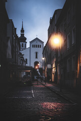 wąska ulica wieczorem w Opolu z kościołem na górce