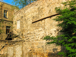 An old, dilapidated brick building in the afternoon sunlight.  Image has copy space.