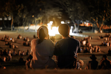 silhouette of young couple enjoying on outdoor romance concert at night