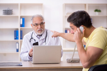 Young male patient visiting old male doctor