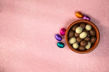 Easter. Composition with chocolate Easter eggs on pink background, space for text. top view Happy...
