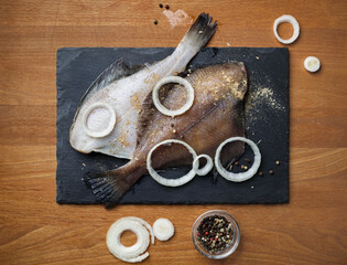 Cooking delicious flounder with spices, pepper and onions. Flat lay.