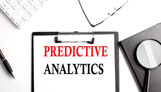 PREDICTIVE ANALYTICS text written on paper clipboard with office tools