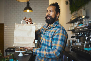 Cafe, takeaway bag and cashier man or small business owner with sustainable restaurant in customer...