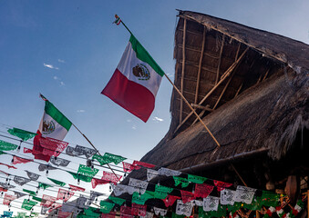 Flag and flags on the fifth avenue of Playa del Carmen in the Mayan Riviera of Mexico, this is an...