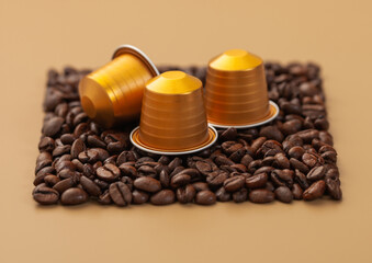 Coffee capsules suitable for machine on square coffee beans texture on beige background.